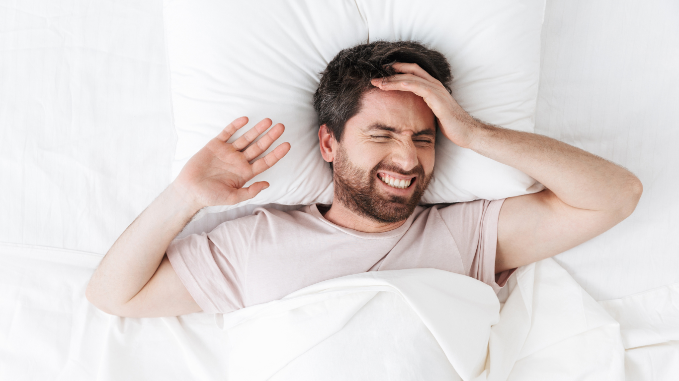 man with migraine while sleeping