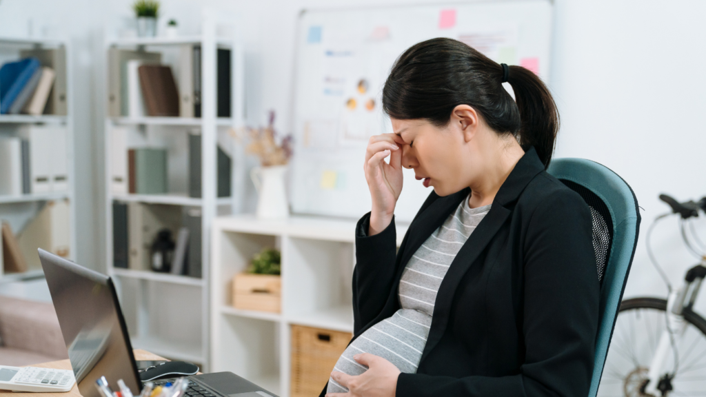 Pregnant woman with migraine at work