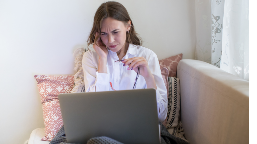 Woman with migraine at laptop