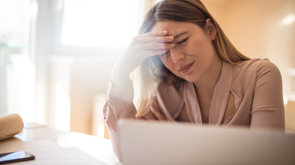 Woman with migraine at work